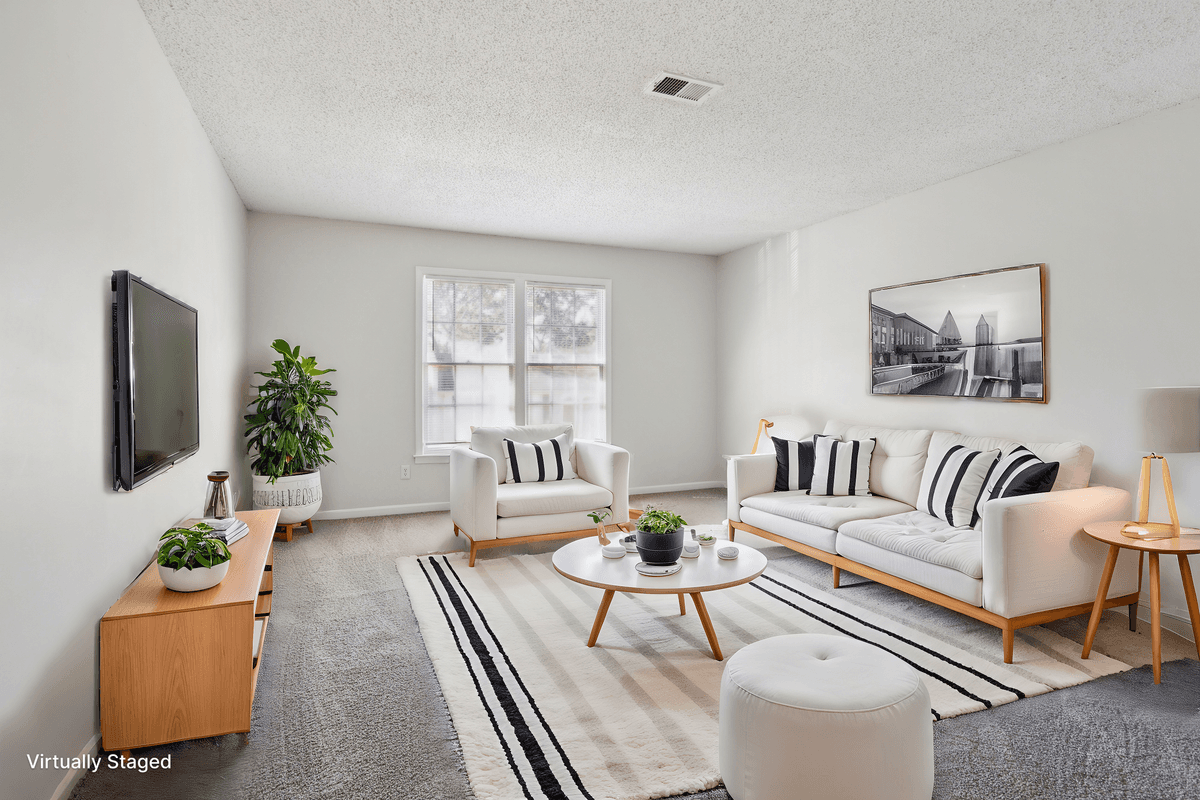 Virtually staged living room with natural light in a Quail Run apartment home